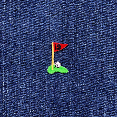 Embroidered golf flag patch on denim fabric