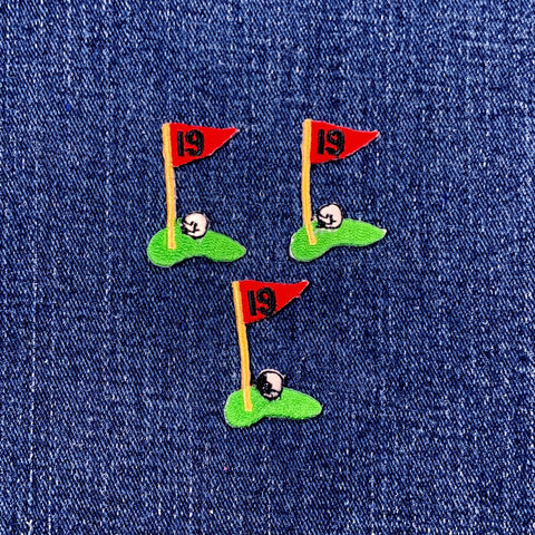 Three embroidered golf flag patches with number 19 on a denim background