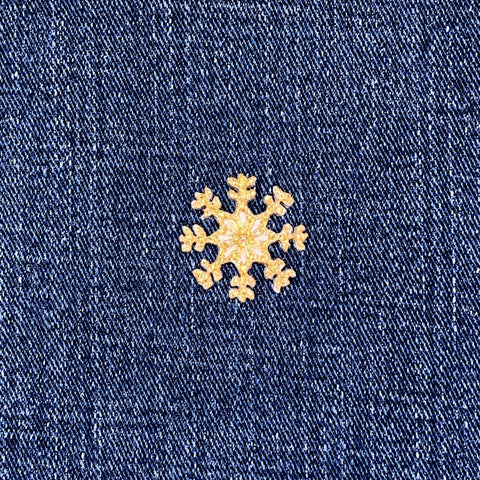 Gold snowflake patch on blue denim fabric