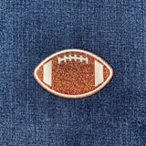 Glittery football-shaped patch on denim fabric