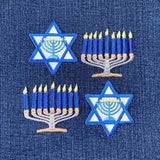Embroidered patches of Menorahs and Star of David on a blue denim background