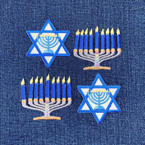 Embroidered patches of Menorahs and Star of David on a blue denim background