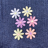 Set of colorful daisy flower-shaped patches on a denim background