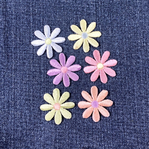 Set of colorful daisy flower-shaped patches on a denim background