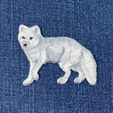 White embroidered fox patch on blue denim fabric