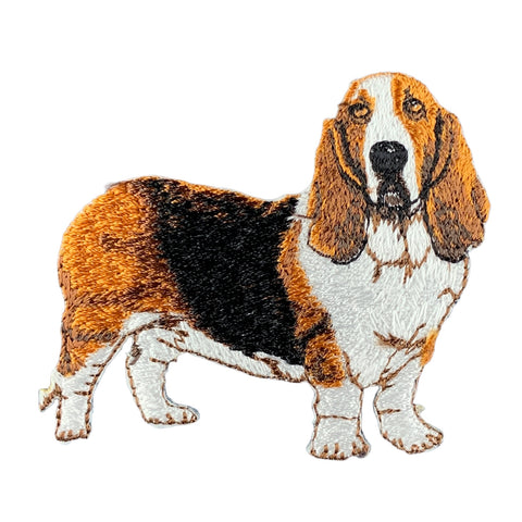 An embroidered basset hound patch in brown, white, and black, placed on a white background.