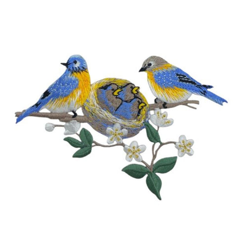 Embroidered patch of two birds on a branch with flowers on a white background