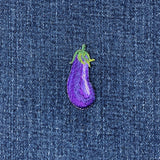 Embroidered purple eggplant patch on a denim background