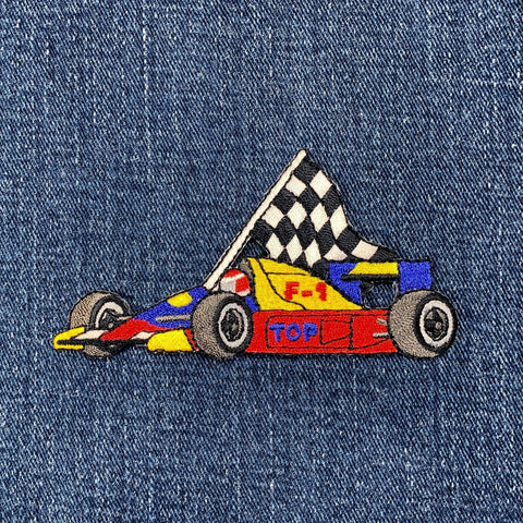 Embroidered racing car patch with a checkered flag on denim fabric