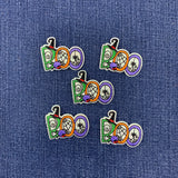 Five Halloween-themed embroidered patches spelling 'BOO' in green, orange, purple, and white, arranged on a blue denim fabric background.