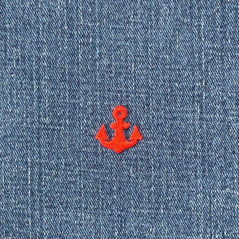 Red anchor embroidered on blue denim fabric