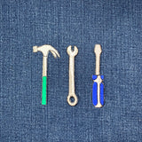 Three tool patches (hammer, wrench, screwdriver) on a denim background