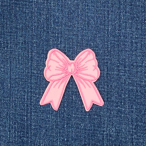 Pink bow patch on a denim background