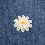 White layered daisy flower patch on blue denim fabric