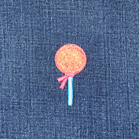 Pink lollipop patch on a denim background