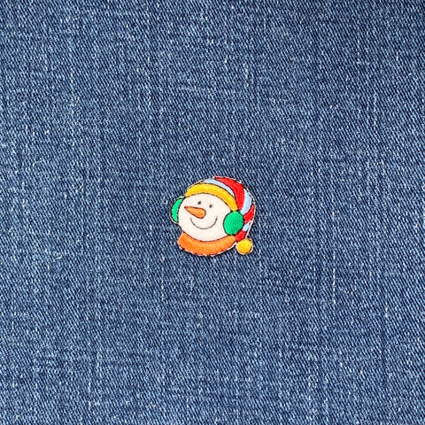 Embroidered snowman patch on denim fabric