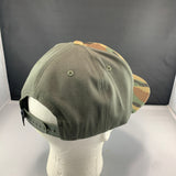 Green cap with camouflage visor on a mannequin head against a black background