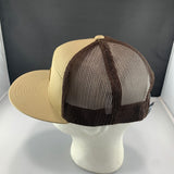 Beige and brown trucker hat on a mannequin head against a dark background