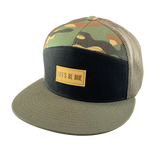 Camouflage trucker hat with a black front panel, an olive bill, and 'Let's Be Irie' patch on a white background