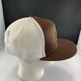 Brown and white cap on a mannequin head with a dark background