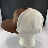 Brown and beige mesh cap on a mannequin head against a black background