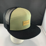Loden and black cap with a "Let's Be Irie" patch on a black background