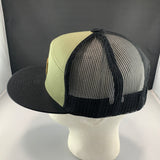 Trucker hat with black mesh back and green front panel on a mannequin head against a gray background