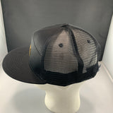 Black mesh cap on a mannequin head with a plain background