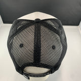 Black mesh cap on a white stand with a black background