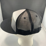 Black and white trucker hat on a mannequin head against a gray background