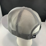 Gray mesh cap on a mannequin head with a black label against a dark background