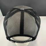 Black mesh cap on a white stand with a gray background