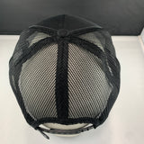 Black mesh cap on a white surface with a dark background