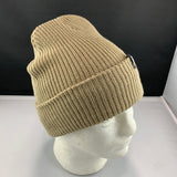 Beige knit beanie on a mannequin head against a black background