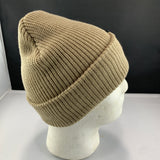 Beige knit beanie on a mannequin head against a black background