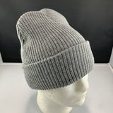 Gray knit beanie on a mannequin head against a black background