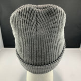 Gray knit beanie on a mannequin head against a black background