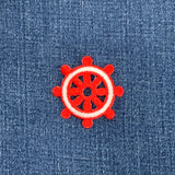 Red and white wheel patch on blue denim fabric