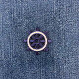 Decorative patch with a ship's wheel design on denim fabric