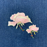 2 pink rose patches on a denim background