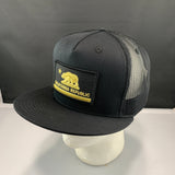 Black trucker hat with California Republic patch on a mannequin head against a gray background