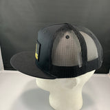 Black and gray mesh cap on a mannequin head against a dark background