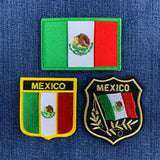 Three embroidered Mexico-themed patches displayed on a blue denim background: a rectangular flag patch at the top, a shield patch with 'MEXICO' and the Mexican flag at lower left, and a black shield patch with 'MEXICO' and a waving Mexican flag with laurel branches at lower right.