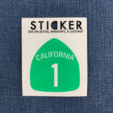 California highway 1 sticker displayed on a denim background