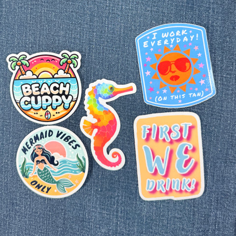Set of 5 colorful stickers with beach-themed designs on a denim background