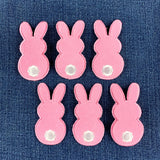 six fuzzy pink bunny patches on a denim background