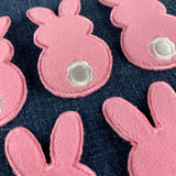fuzzy pink bunny patches on a denim background
