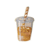 An embroidered patch shaped like a clear plastic cup filled with orange-yellow iced coffee, with a striped straw
