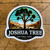 A vinyl decal featuring a stylized representation of Joshua Tree National Park with a tree and a sunset in the background, and the text 'JOSHUA TREE NATIONAL PARK' along with 'USA'.