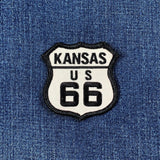 Embroidered Kansas Route 66 shield patch with black text on a white background, centered on a textured blue denim fabric.